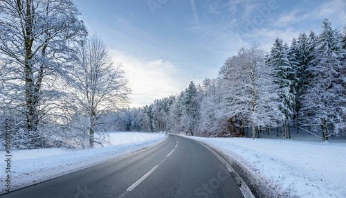 In a winter landscape in Germany, a snow-covered curve road and snow-covered trees.