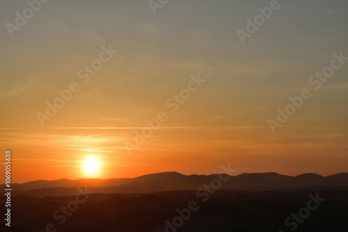 The sunset and its rays dazzle the green forests and meadows photo