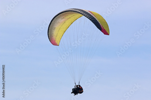 Tandem Paraglider flying in a cloudy sky	 photo