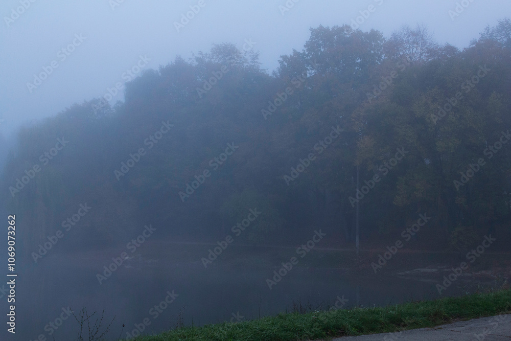 Autumn in Moldova, foggy landscape in the park. Thick fog early in the morning on the lake shore.