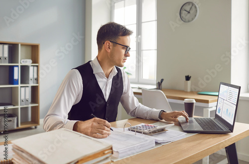 Canvastavla Portrait of a focused businessman accountant works in the office or at home office, seated at a desk adorned with papers and a laptop, he delves into financial intricacies with a serious demeanor