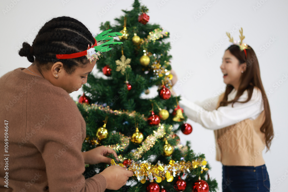 Group young diverse friends decorating the Christmas tree with smiles and holiday cheer Group young diverse friends decorating the Christmas tree with smiles and holiday cheer