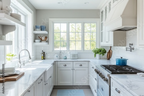 A Modern White Kitchen with Marble Countertops and a Window View