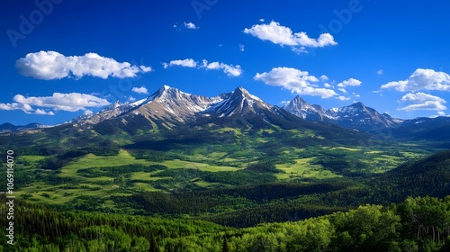 A majestic mountain range with snow-capped peaks towering above lush green valleys below