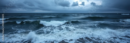 The ocean churns under a stormy sky, waves crashing and churning in the early morning light photo