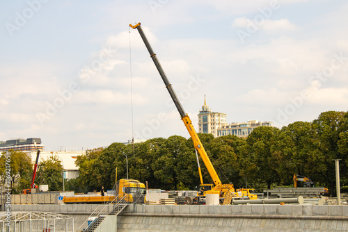 A truck crane and other specialized mechanized equipment are used in the construction of the embankment photo