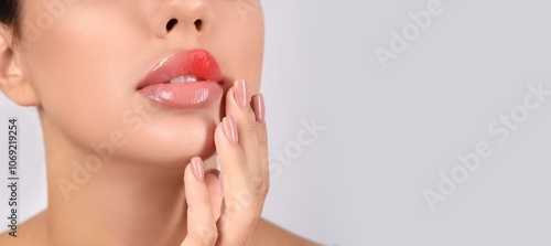 Young woman with cold sore on lip against light background with space for text, closeup