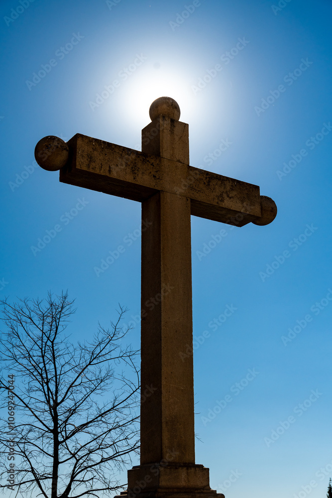 Majestic Stone Cross Bathed in Sunlight Against Blue Sky Majestic Stone Cross Bathed in Sunlight Against Blue Sky