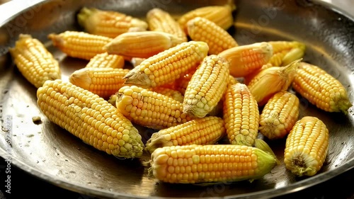 Golden corn cobs cooking in a hot wok