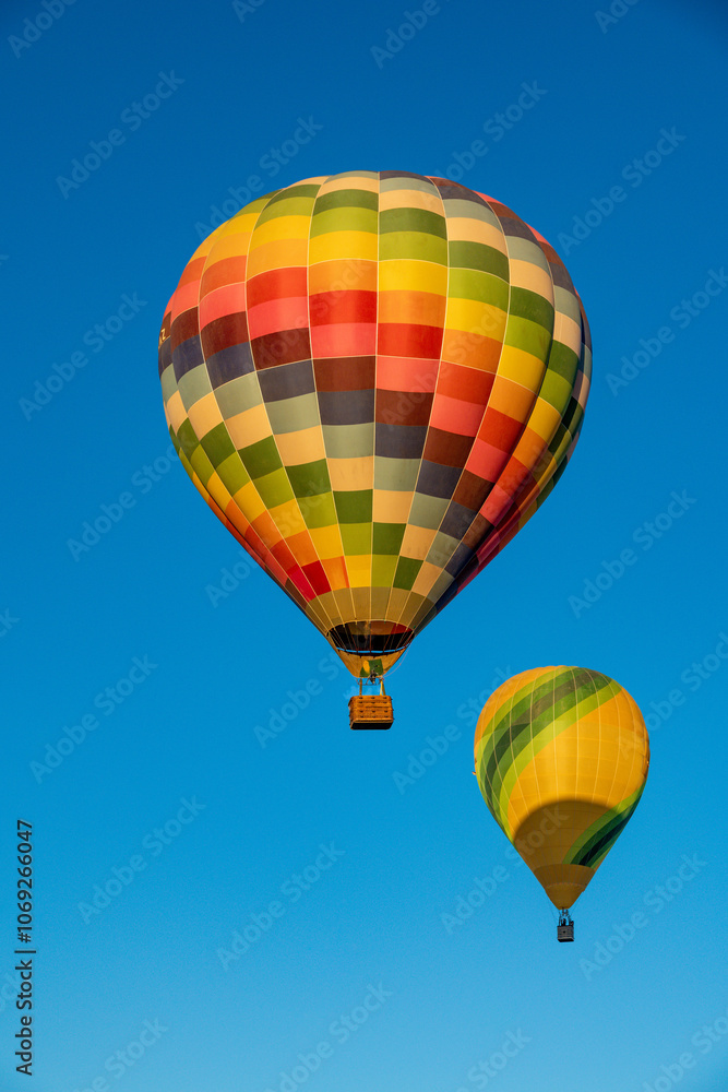 Naklejka premium Colorful Hot Air Balloons Ascending in Clear Blue Sky