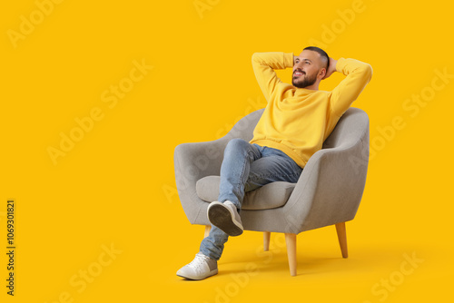 Young man resting in armcha...