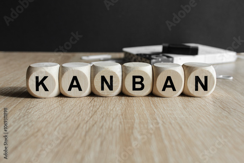 Obraz na płótnie Writing the word KANBAN on wooden cubes. Beautiful wooden table, black background. Info concept. w salonie