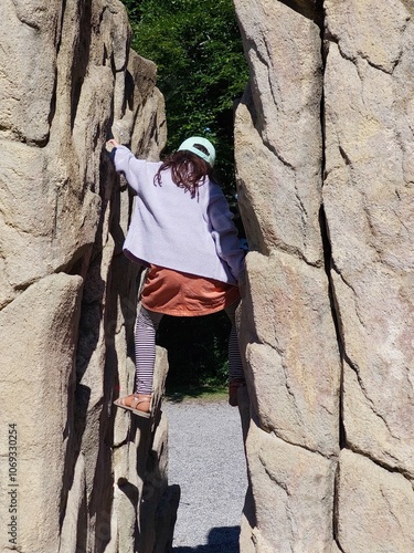 Girl climbing between two rocks