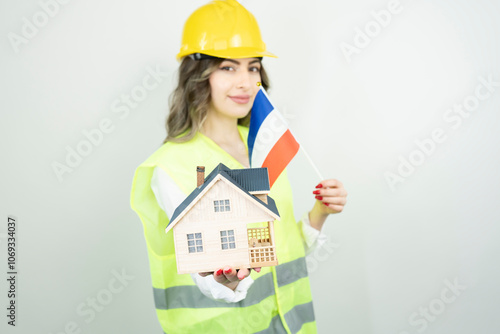 Home inspector woman or engineer holding France flag and detached house model