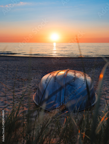  beach scene at sunset, with a boat resting on the sand