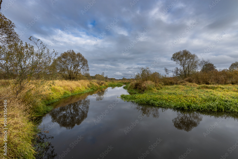 A calm river with trees on either side A calm river with trees on either side