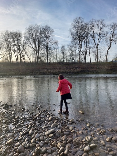Girl balancing on stones at riverbank