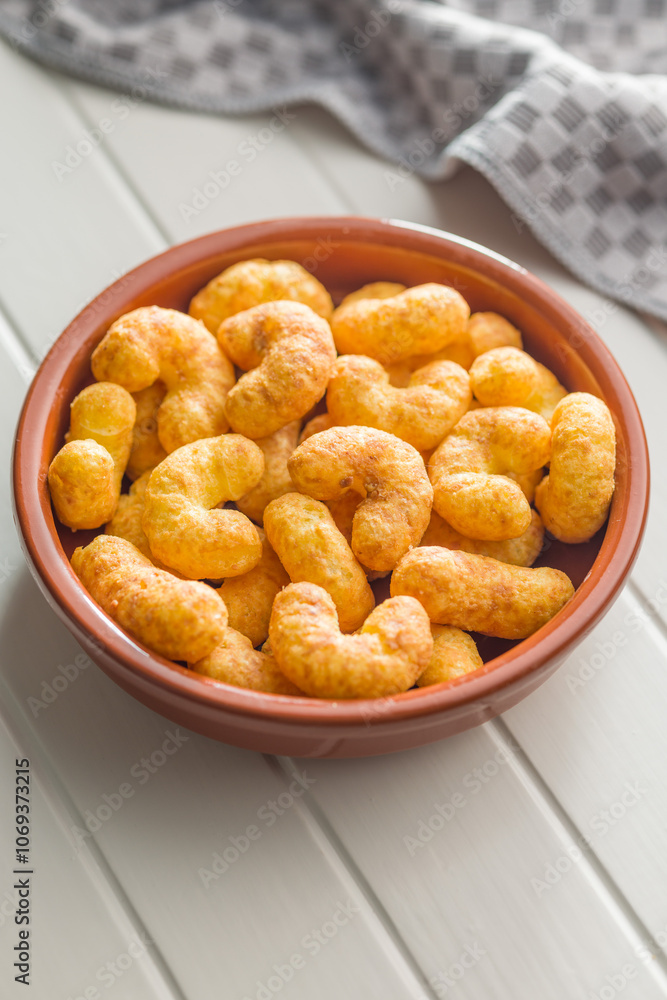 Puffed crispy Peanut flips in bowl on white table. Puffed crispy Peanut flips in bowl on white table.