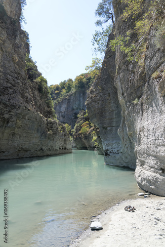 Osumi Gorge, Albania - August 15 2024: Stunning view of Osumi Canyon (Albanian: Kanioni i Osumit), showcasing the breathtaking cliffs, vibrant greenery, and winding river through dramatic landscape. photo