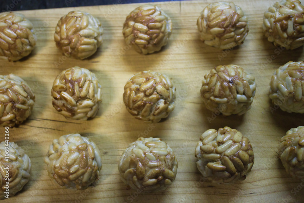 Delicious marzipan balls made with pine nuts and sweet syrup prepared on a wooden surface Delicious marzipan balls made with pine nuts and sweet syrup prepared on a wooden surface