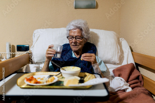 Elderly woman enjoying meal in assisted living room setting