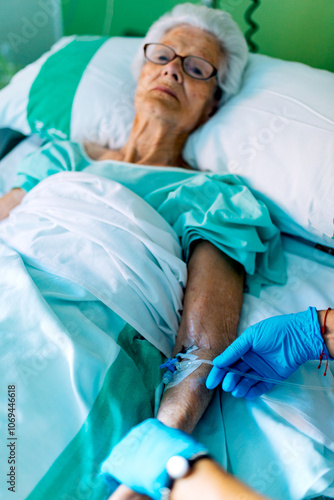 Elderly Woman Receiving Medical Care in a Hospital Bed photo