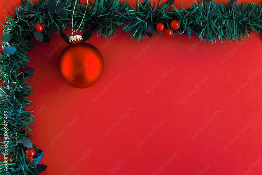 Festive Christmas decorations, garland with red berries and a red ball christmas tree ornament on a red background copyspace for season, Christmas or New Year greetings. Festive Christmas decorations, garland with red berries and a red ball christmas tree ornament on a red background copyspace for season, Christmas or New Year greetings.