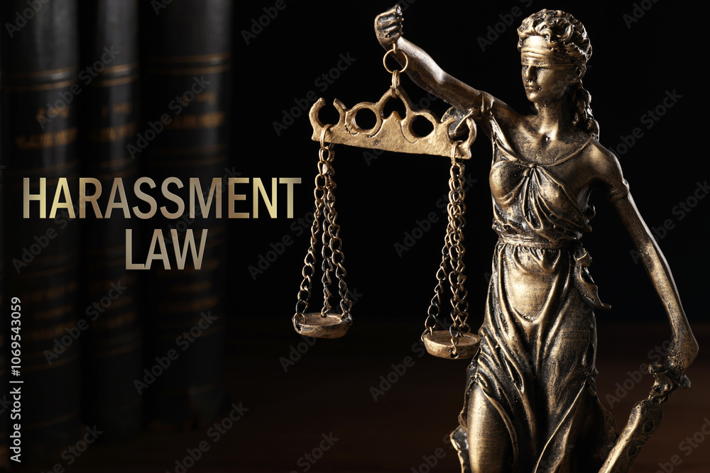 Harassment law. Statue of Lady Justice and books on dark background Harassment law. Statue of Lady Justice and books on dark background