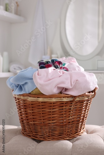 Laundry detergent and clothes in basket indoors