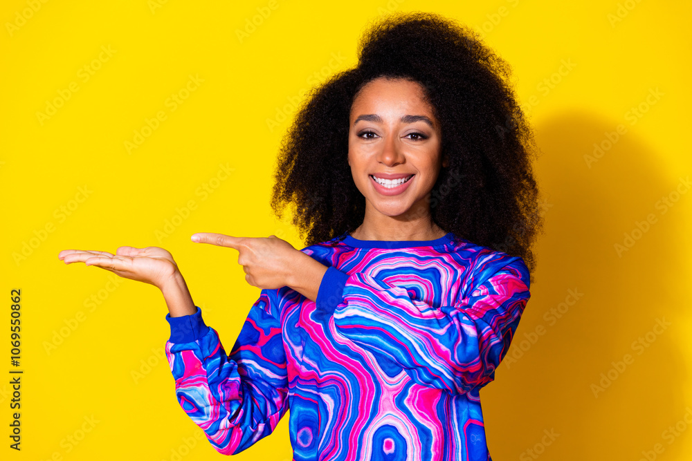 Photo portrait of attractive young woman point hold empty space dressed stylish colorful blue clothes isolated on yellow color background Photo portrait of attractive young woman point hold empty space dressed stylish colorful blue clothes isolated on yellow color background