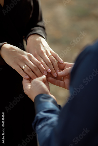 A couple in love touches each other with their hands. Love story of a young couple in love. Wedding rings on ring fingers. Concept of a marriage proposal. Starting a family.