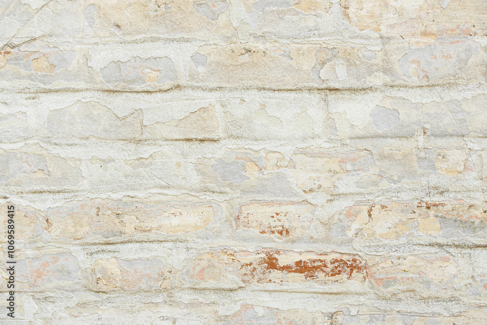 Fototapeta premium Beige grungy brick wall. Free space for an inscription. Can be used as a background or poster. Fragment of a wall with bumps and shabby plaster.