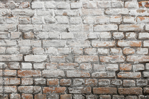 White shabby grungy brick wall. Free space for an inscription. Can be used as a background or poster. Fragment of a red brick wall with bumps and textured plaster. 