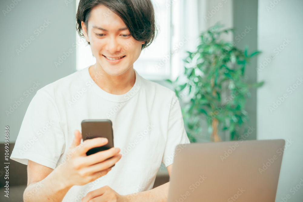 スマホとノートパソコンを使う男性
スマホとノートパソコンを使う男性