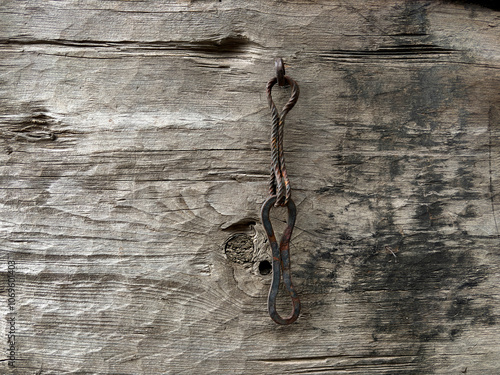 A rusty metal object is sitting on a wooden surface photo