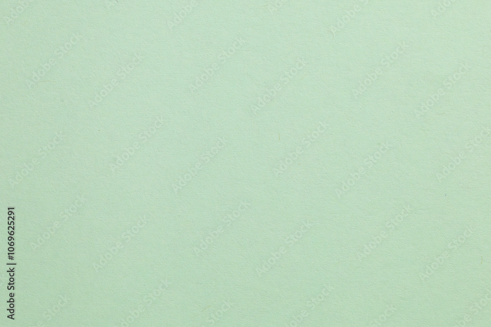 A green background with a white object in the middle, textured origami paper backdrop