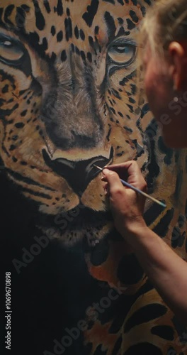 Woman Painting Leopard on Wall photo