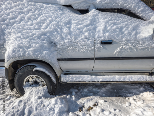 snow covered old white SUV car at sunny white winter day photo