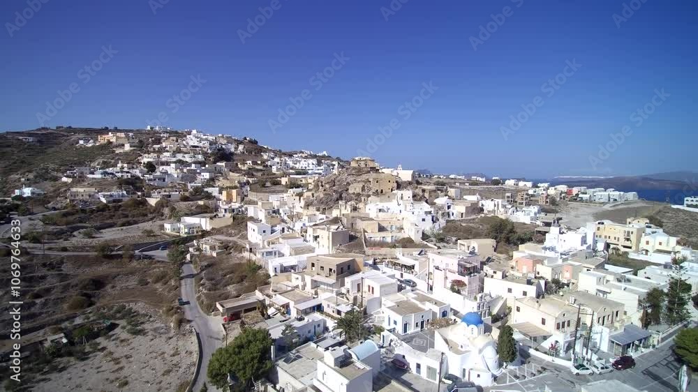 Scenic view of a Greek hillside village with white and pastel-colored buildings under a bright blue sky, surrounded by rugged terrain and distant views of the Aegean Sea. Scenic view of a Greek hillside village with white and pastel-colored buildings under a bright blue sky, surrounded by rugged terrain and distant views of the Aegean Sea.