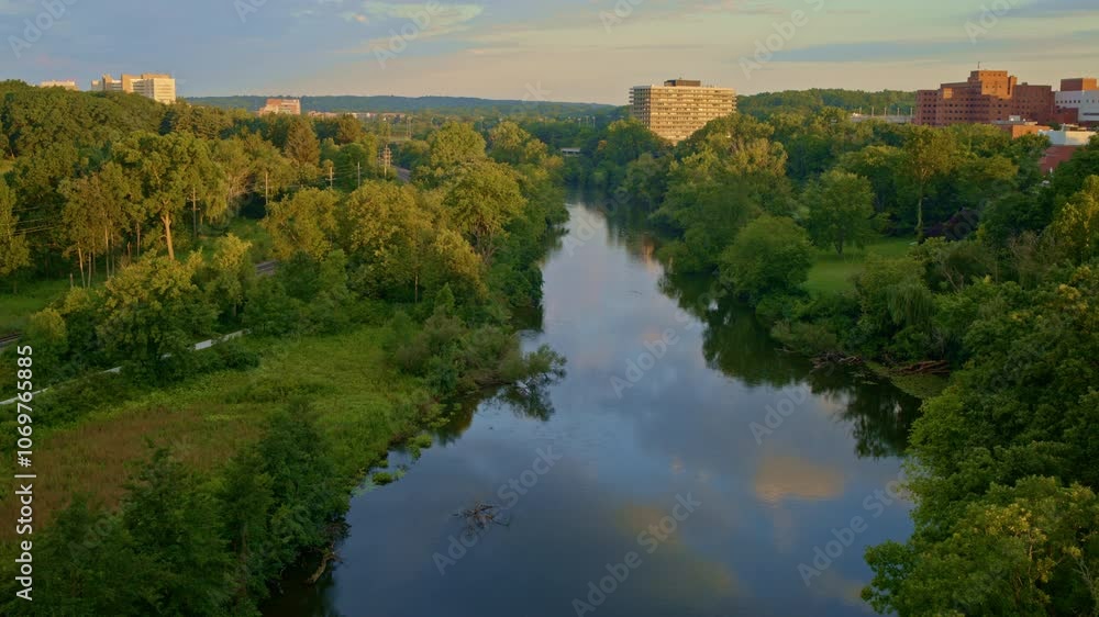 Slowly drifting drone view over the Huron River in Ann Arbor, Michigan, in summer. Slowly drifting drone view over the Huron River in Ann Arbor, Michigan, in summer.
