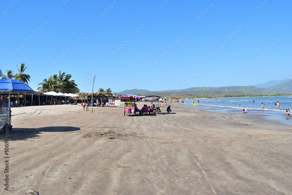 San Blas, Mexico - May 25 2024: View of Islitas beach with some people with umbrellas and street vendors San Blas, Mexico - May 25 2024: View of Islitas beach with some people with umbrellas and street vendors