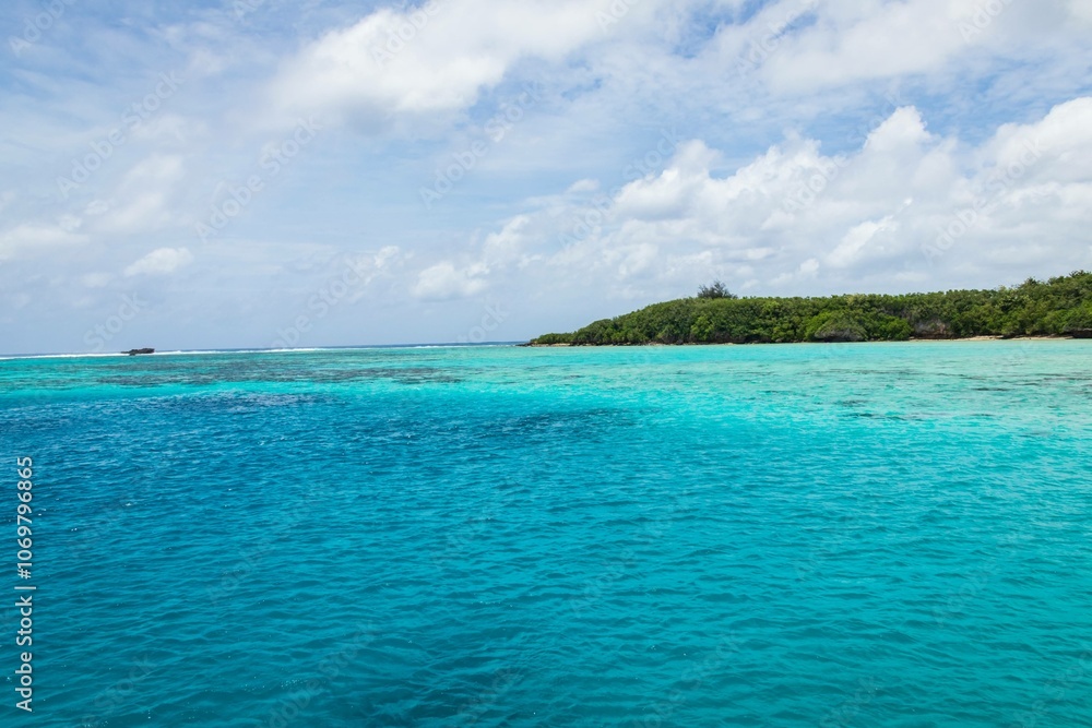 Pristine Turquoise Waters and Lush Green Island Under a Cloudy Sky, Guam Pristine Turquoise Waters and Lush Green Island Under a Cloudy Sky, Guam