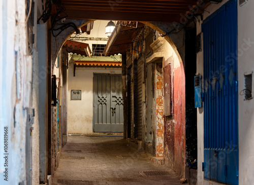 Narrow street in the medina of Tangier, Tanger, Moroco, at night. Chiaroscuro atmosphere. No people.