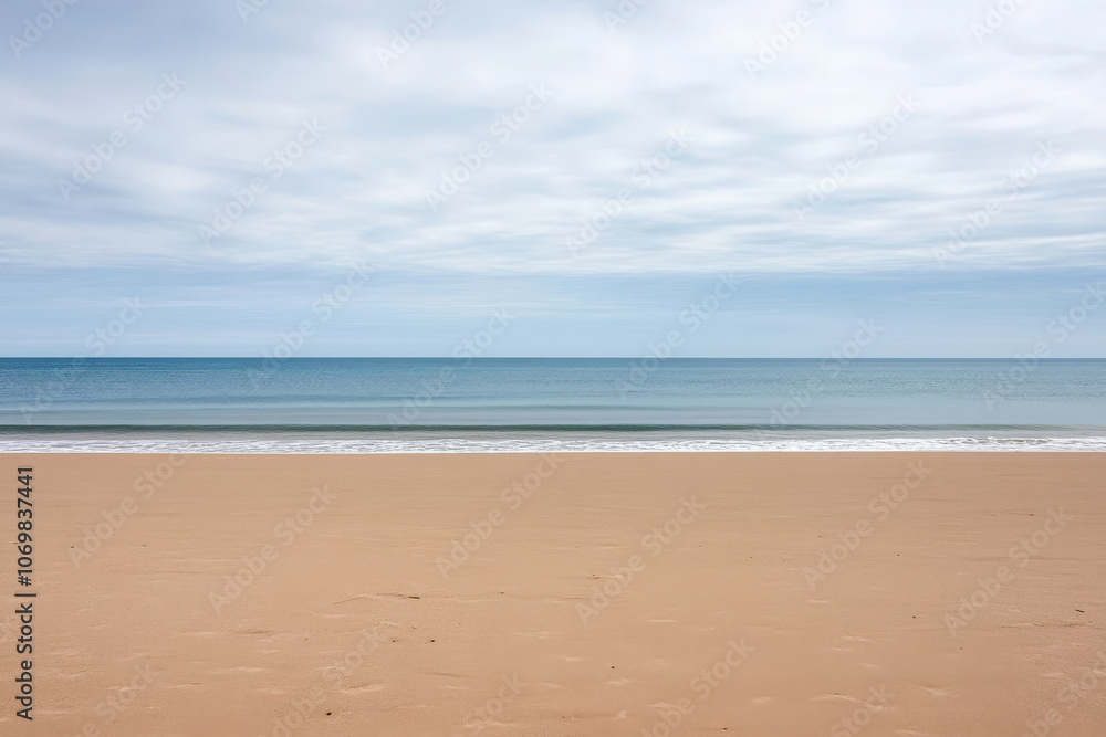 Tranquil beach landscape at dawn with gentle waves lapping the shore and a cloudy sky Tranquil beach landscape at dawn with gentle waves lapping the shore and a cloudy sky