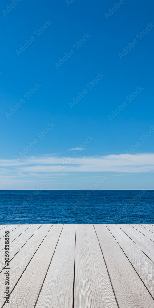 Tranquil seascape viewed from a wooden deck under a clear blue sky with calm ocean waves Tranquil seascape viewed from a wooden deck under a clear blue sky with calm ocean waves