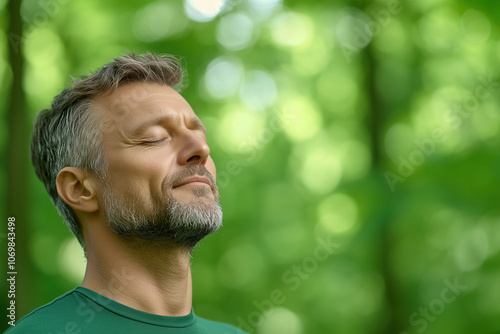 Relaxed Man with Closed Eyes Enjoying Nature in Lush Green Forest, Breathing Deeply, Representing Mindfulness and Calmness photo