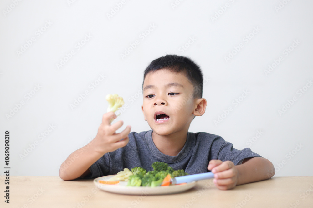 Nutrition healthy eating habits for kids concept. Children do not like to eat vegetables. Little cute boy refuses to eat healthy vegetables. Nutrition healthy eating habits for kids concept. Children do not like to eat vegetables. Little cute boy refuses to eat healthy vegetables.