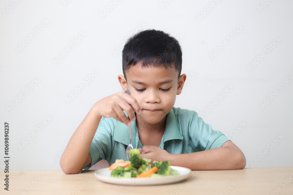 Nutrition healthy eating habits for kids concept. Children do not like to eat vegetables. Little cute boy refuses to eat healthy vegetables. Nutrition healthy eating habits for kids concept. Children do not like to eat vegetables. Little cute boy refuses to eat healthy vegetables.