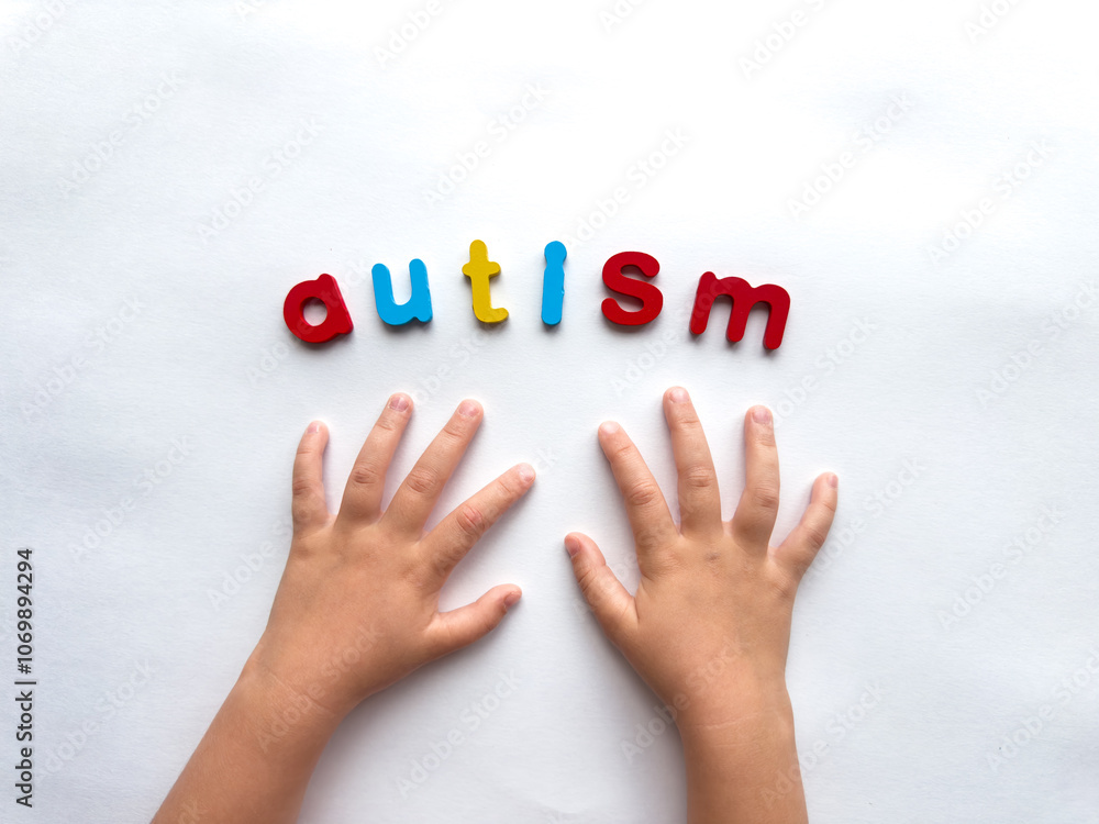 Childs hands and colorful letters spelling autism on white background Childs hands and colorful letters spelling autism on white background