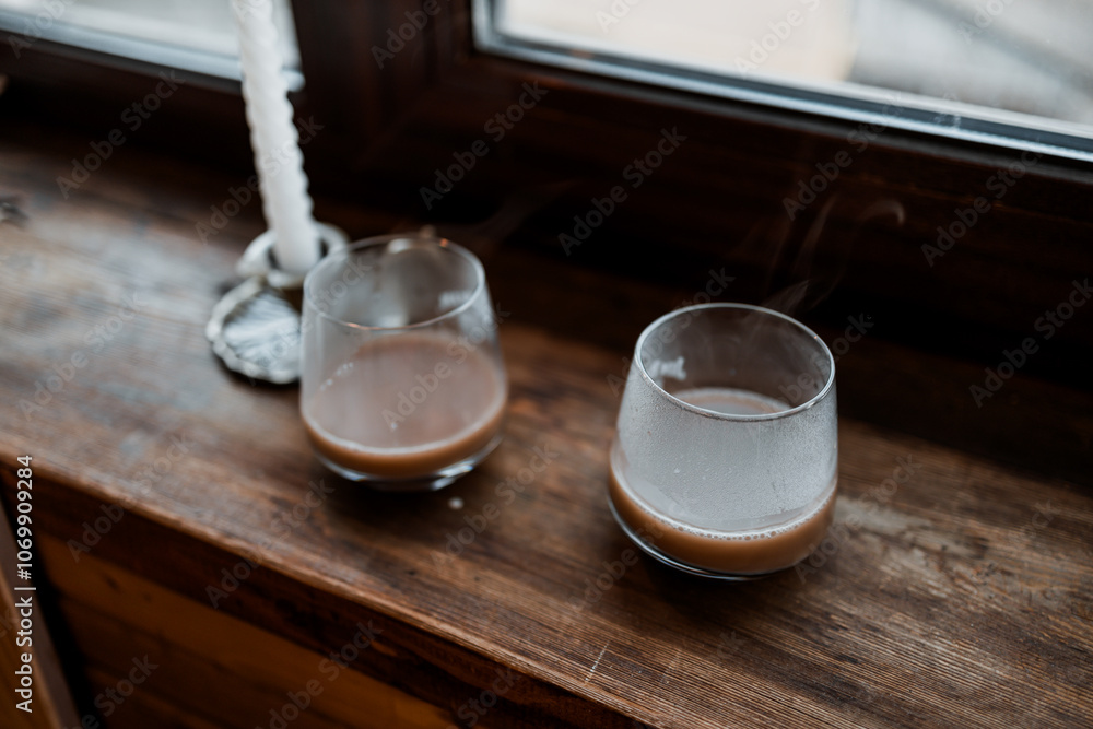 coffee in glass cup with burning candle on wooden table coffee in glass cup with burning candle on wooden table